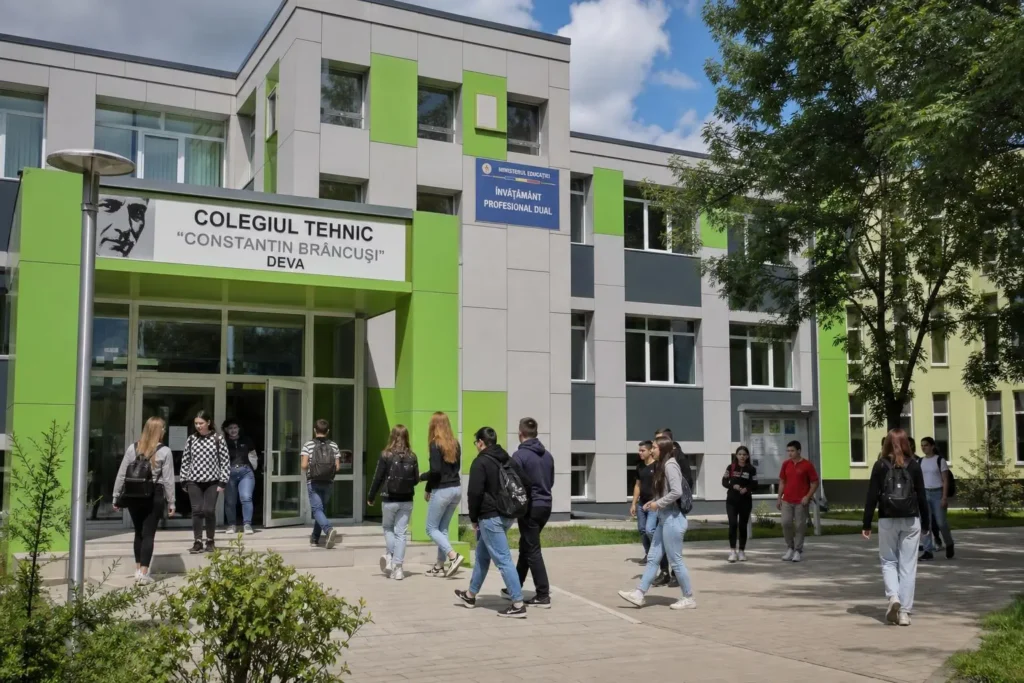 Entrée moderne d’un établissement d’enseignement technique avec des étudiants entrant, façade colorée en vert et gris. formation professionnelle romania dans le contexte.
